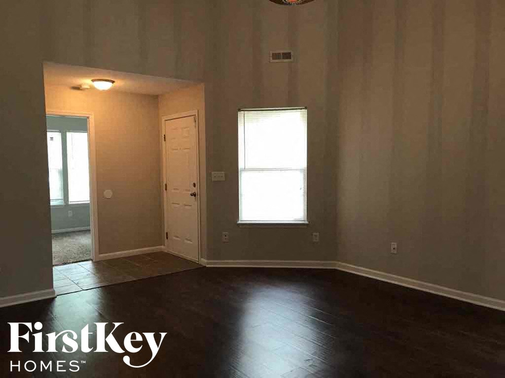 an empty living room with wooden floors and a window