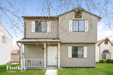 the front of a house with a white door and a porch