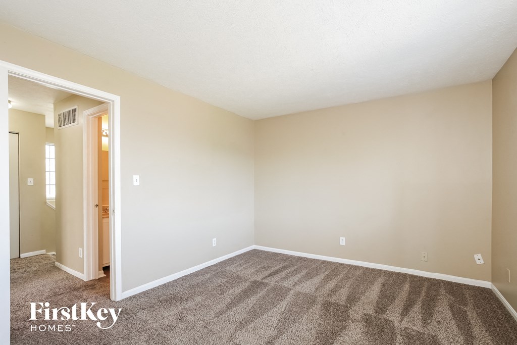 an empty living room with carpet and white walls