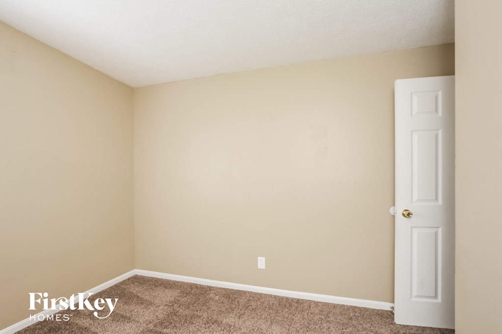 a bedroom with a white door and a carpeted floor