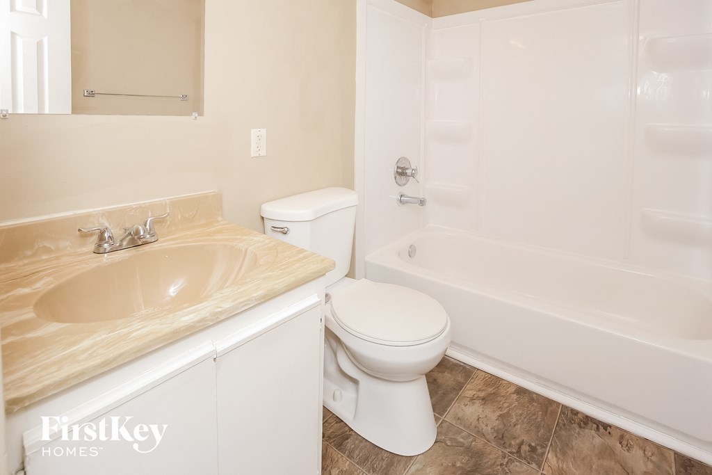 a bathroom with a toilet and a tub and a sink