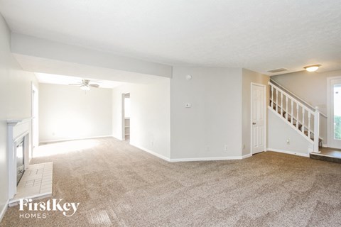 A spacious room with a staircase leading to the second floor.