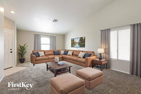 A living room with a brown couch, a coffee table, and a painting on the wall.