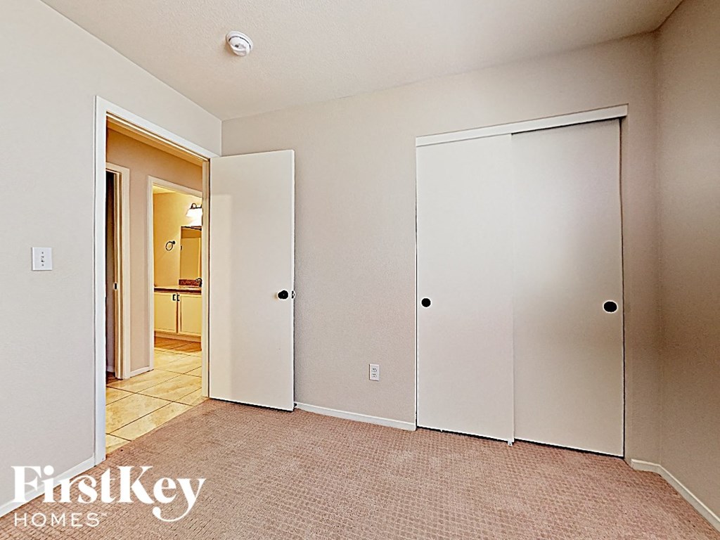 A bedroom with a carpeted floor and two closets.
