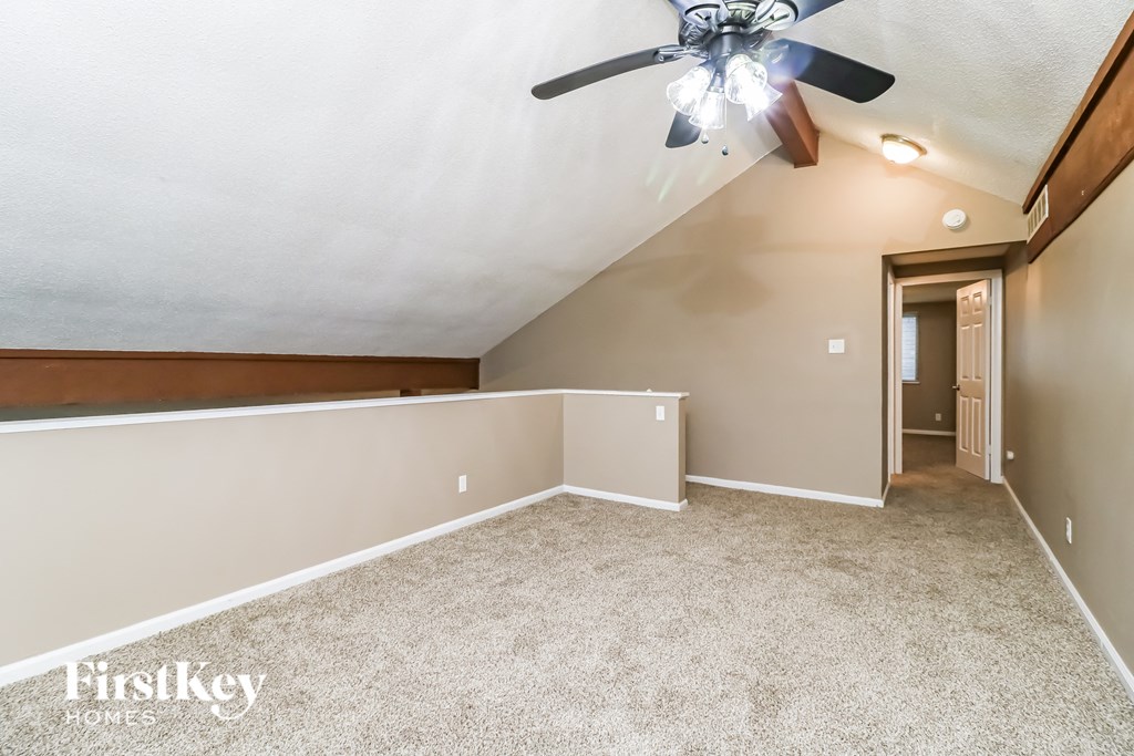 the upstairs bonus room is spacious and has a ceiling fan