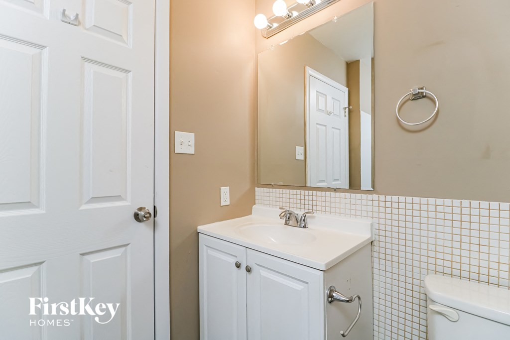 a bathroom with a white sink and a mirror and a white door