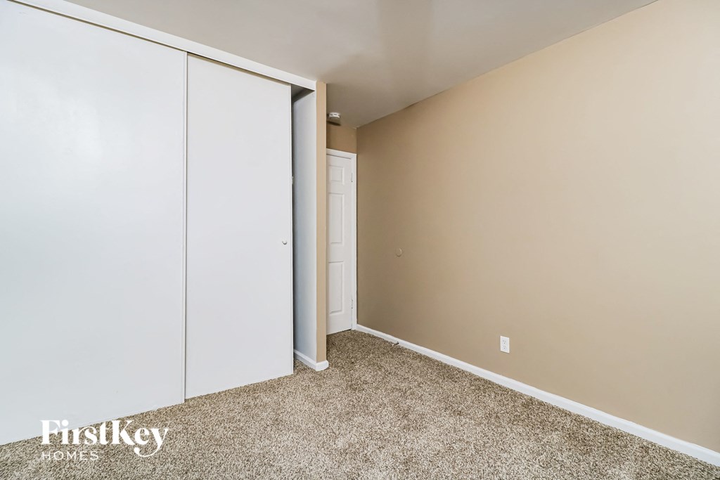 a bedroom with two closet doors and a carpeted floor
