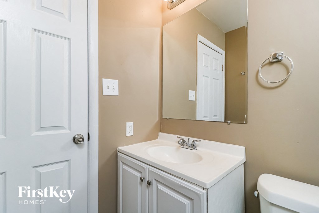 a bathroom with a white sink and a mirror and a white door