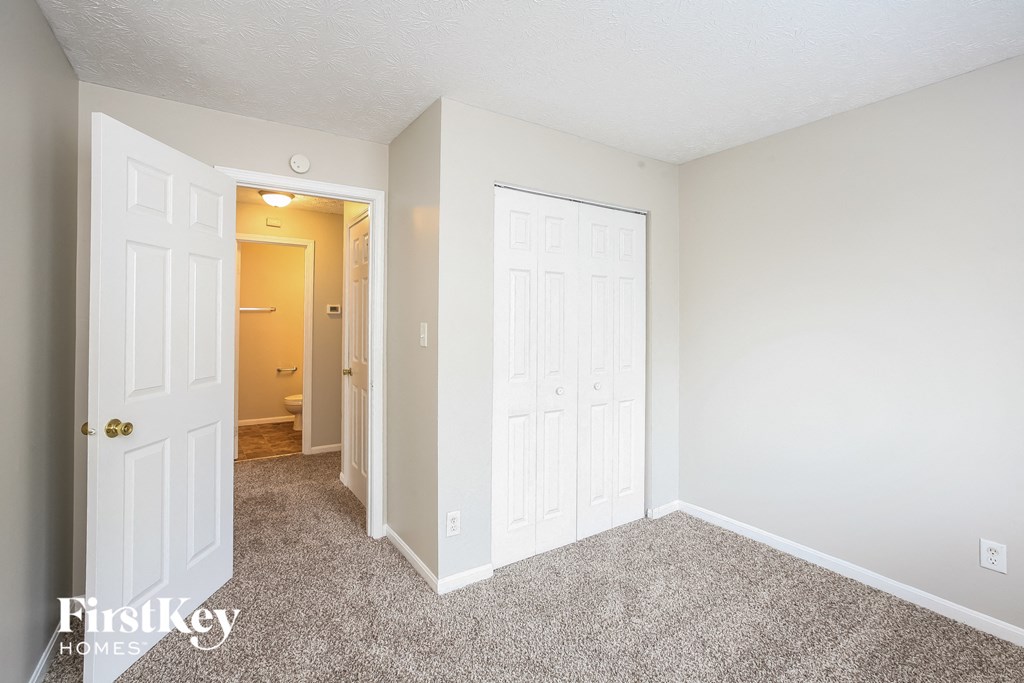 a bedroom with two closets and a door to a hallway