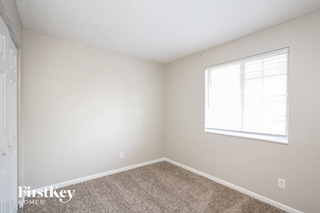 a bedroom with carpet and a window