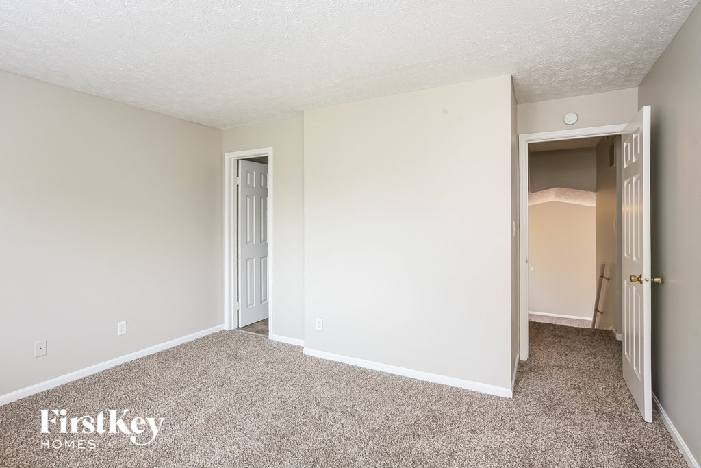 a bedroom with carpet and a door to a closet
