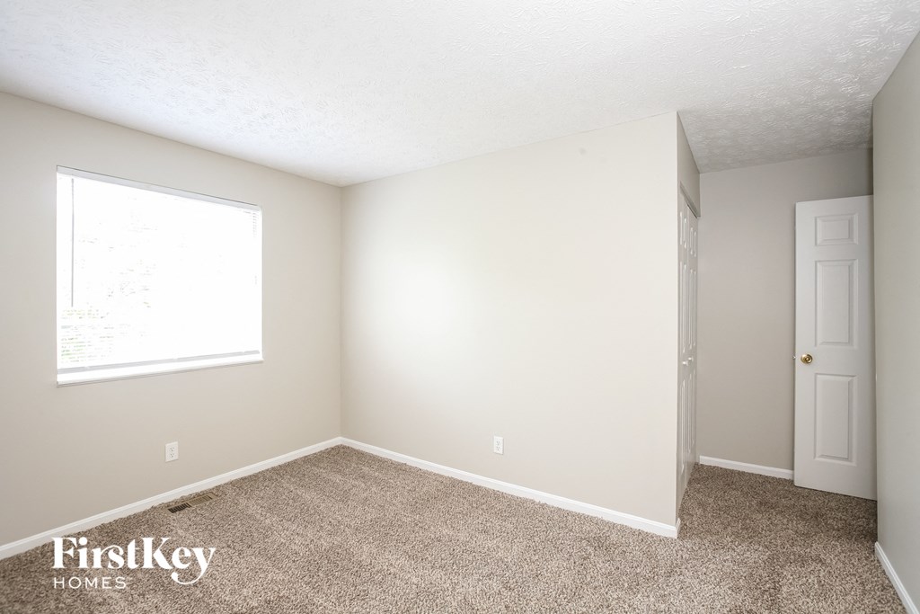 a bedroom with a carpeted floor and a window