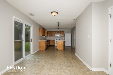 a kitchen with white appliances and wooden cabinets and tiled floors