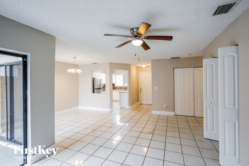 A spacious room with a ceiling fan and tiled flooring.