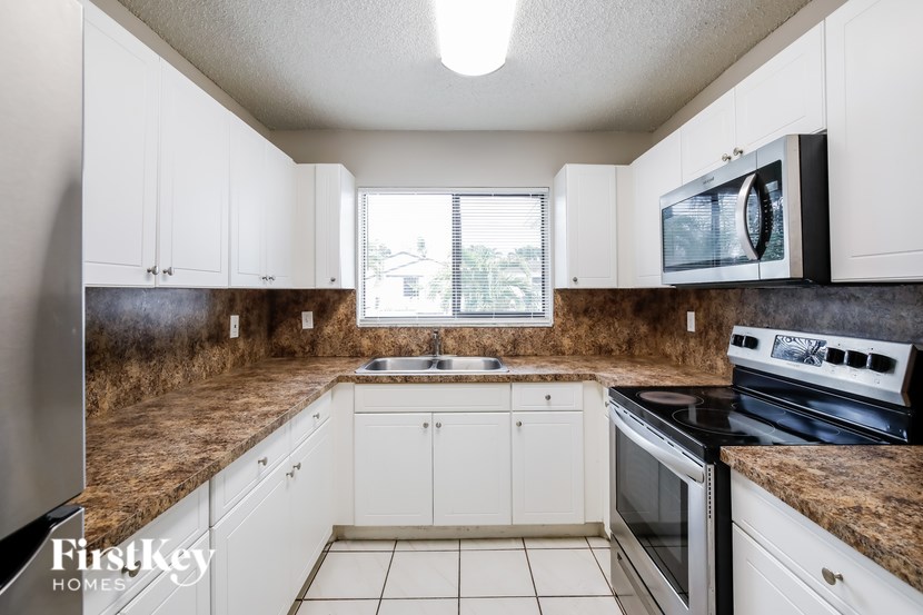 A kitchen with white cabinets and a granite countertop.
