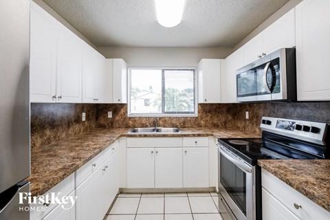 A kitchen with white cabinets and a granite countertop.