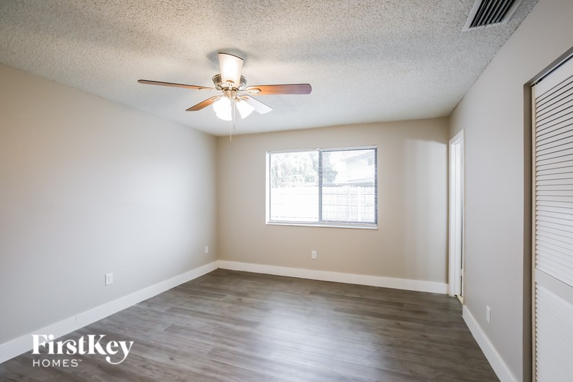 A room with a ceiling fan and a window.