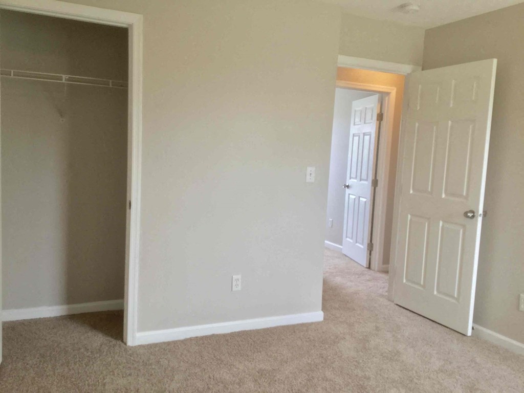 an empty room with a door and a closet