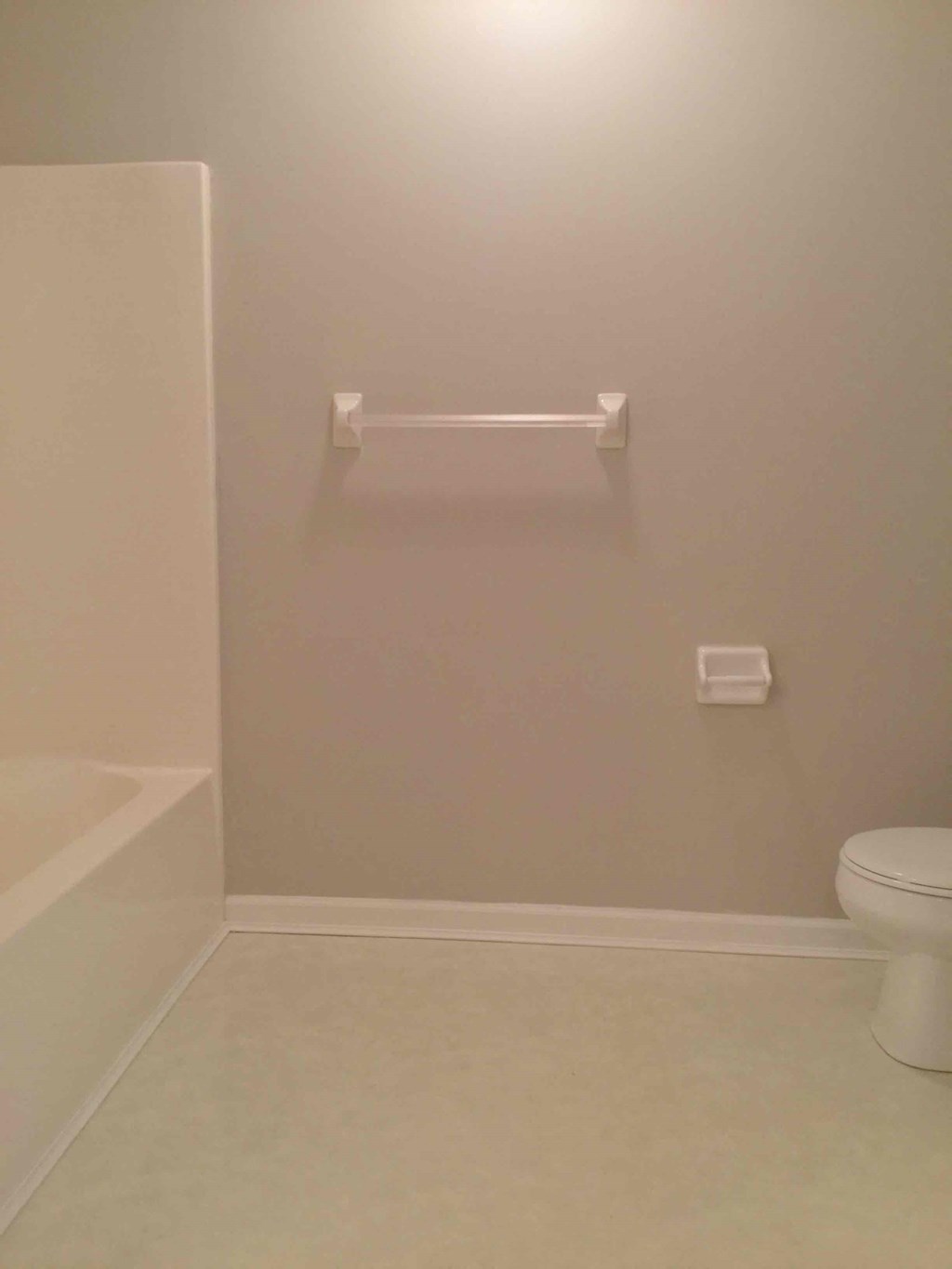 a bathroom with a toilet and a towel rack
