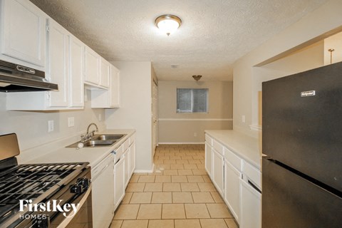 a kitchen with white cabinets and a stove and a refrigerator