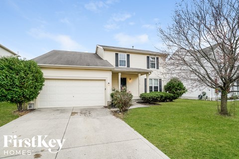a white house with a white garage door and a lawn