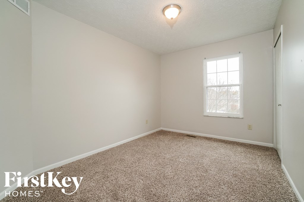 a bedroom with a carpeted floor and a window