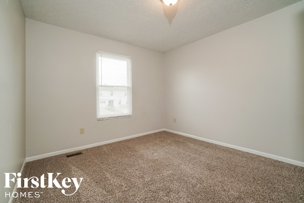 a empty room with carpet and a window