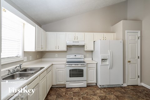 A kitchen with white appliances and cabinets.