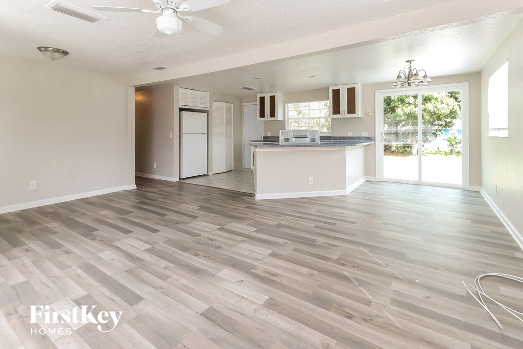 the living room and kitchen of a new home with wood flooring