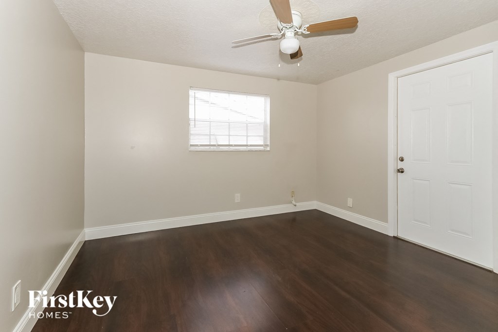 a living room with wood floors and a ceiling fan