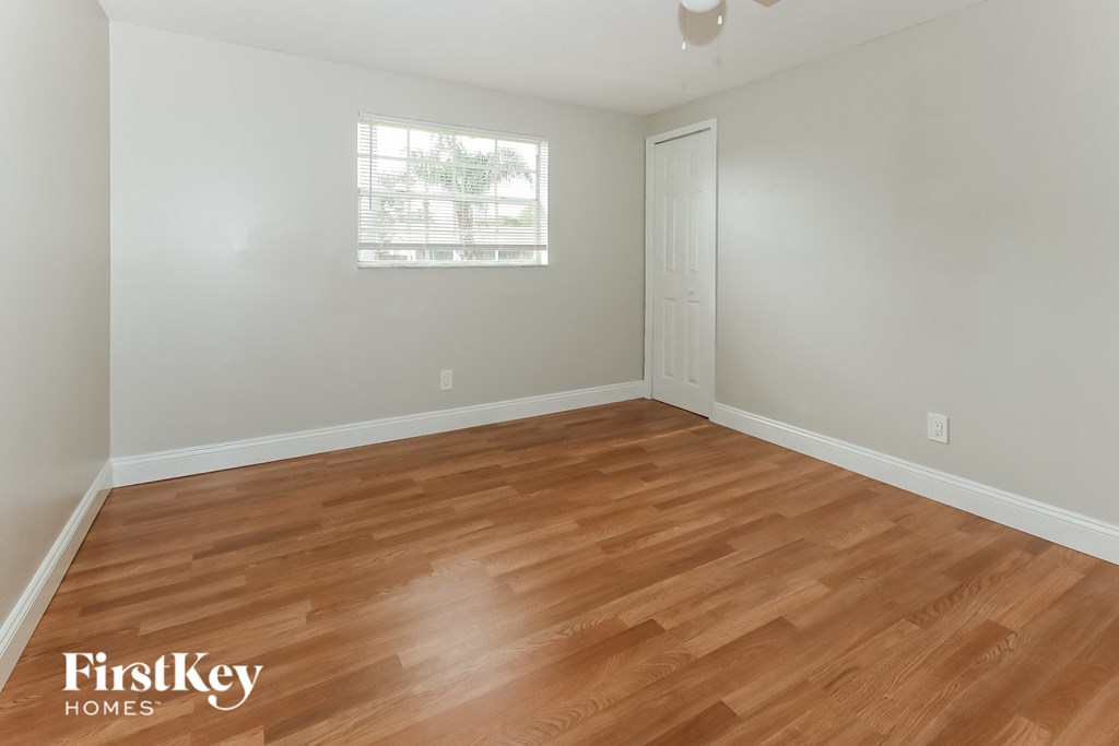 a bedroom with wood flooring and a window