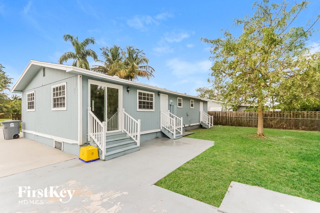 a light blue manufactured home with a porch and a driveway