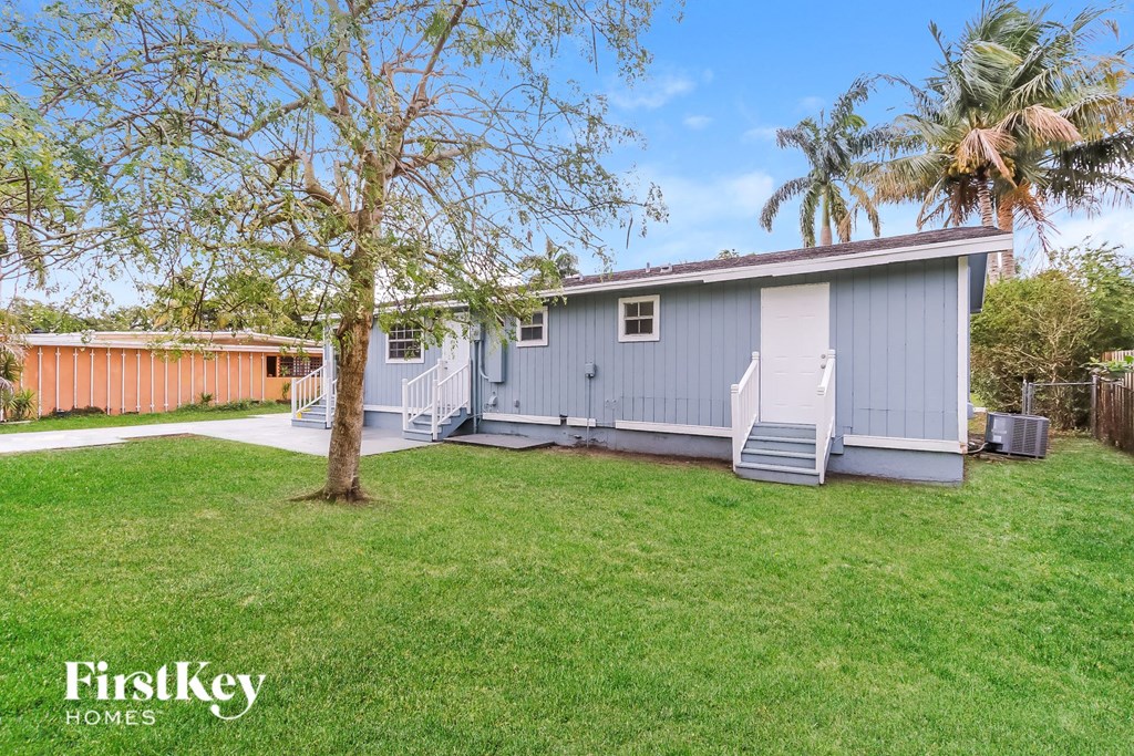 a blue house with a backyard and a tree