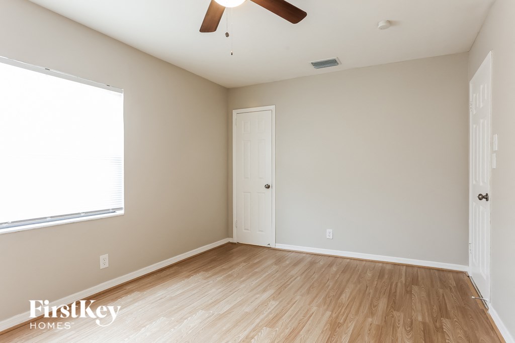 a living room with wood floors and a ceiling fan
