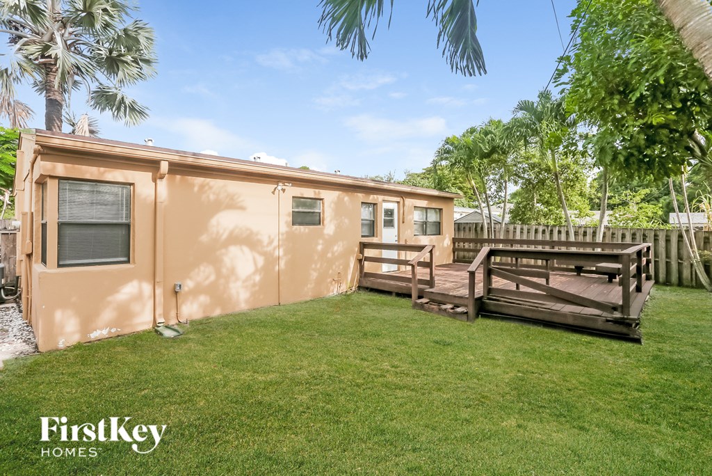 a small house with a backyard and a deck