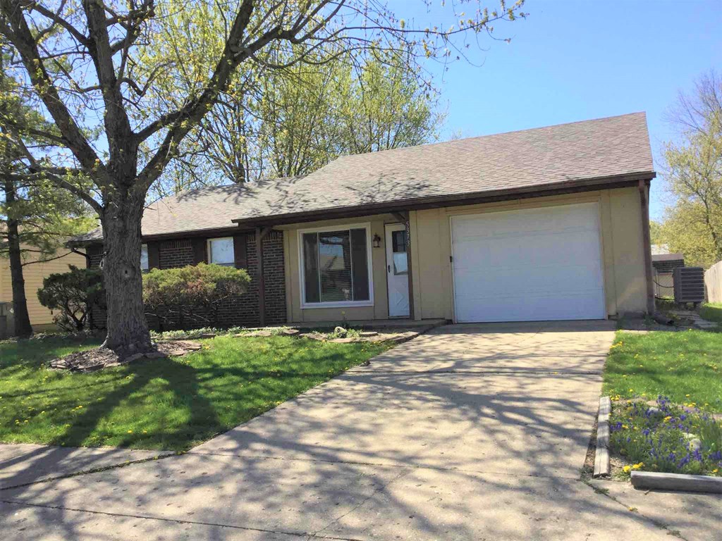 A house with a brown roof and a white garage door.