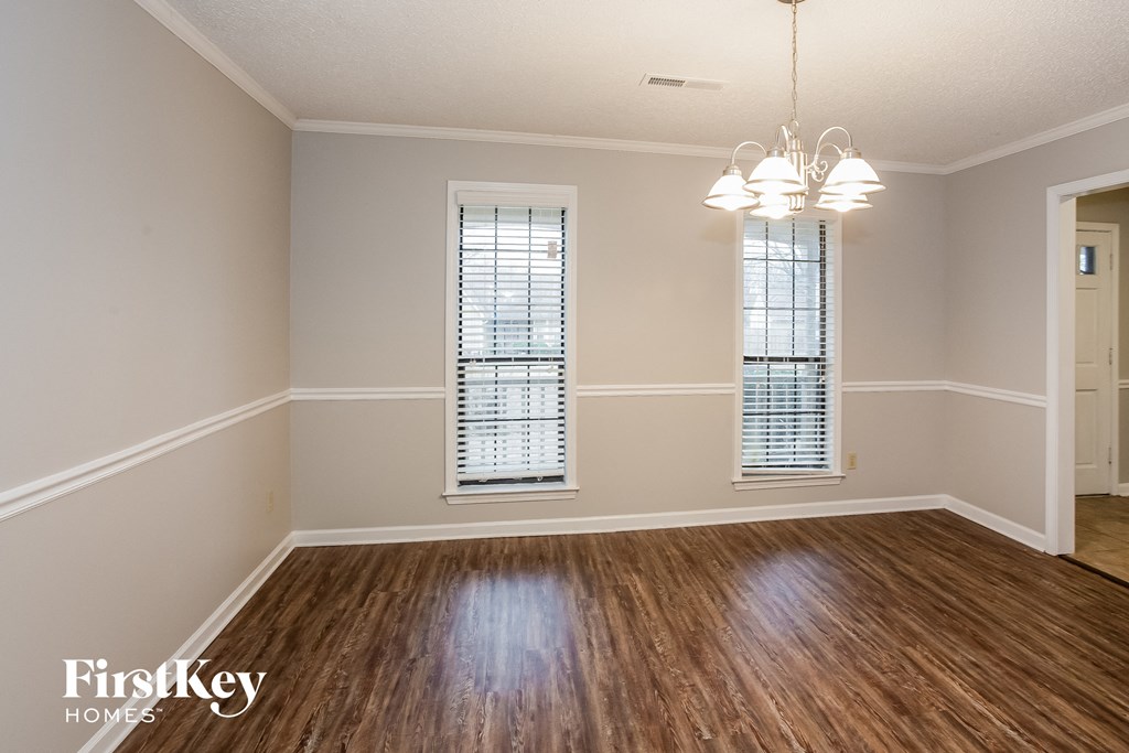 A room with wooden floors and two windows.