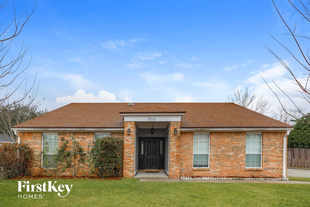 the front of a brick house with a black door