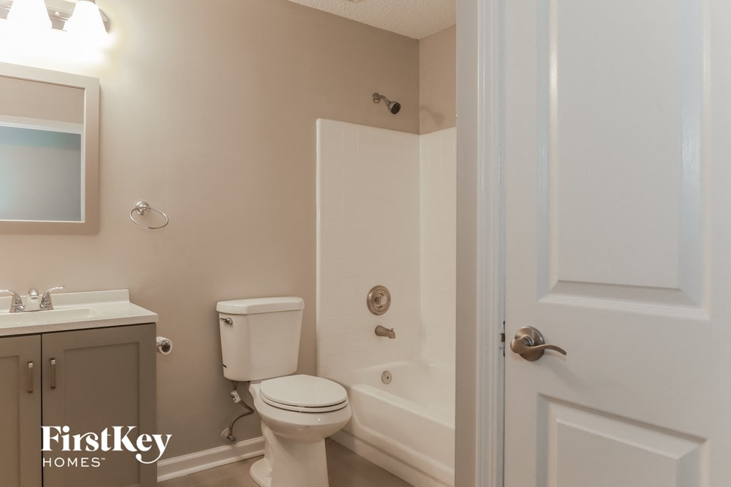 a bathroom with a toilet and a tub and a sink
