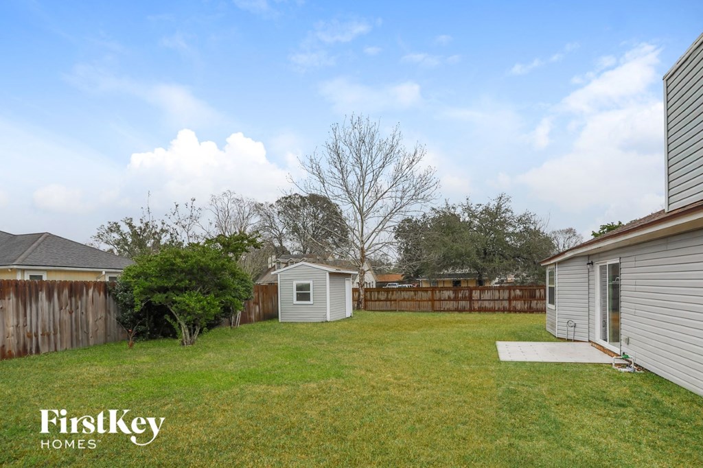 the backyard of a home with a yard and a fence