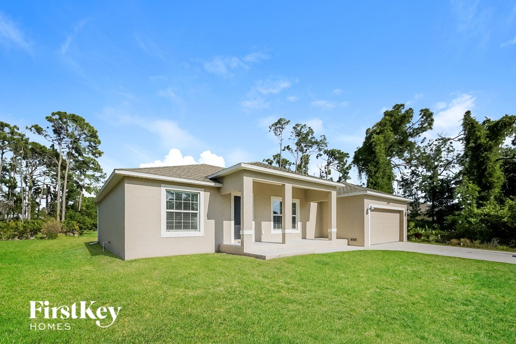 A house with a green lawn and trees in the background is for sale by FirstKey Homes.