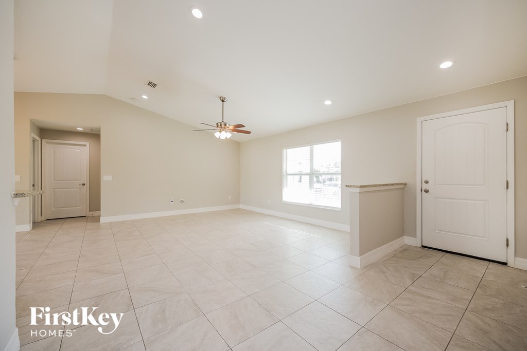 A spacious room with a ceiling fan and a window letting in natural light.