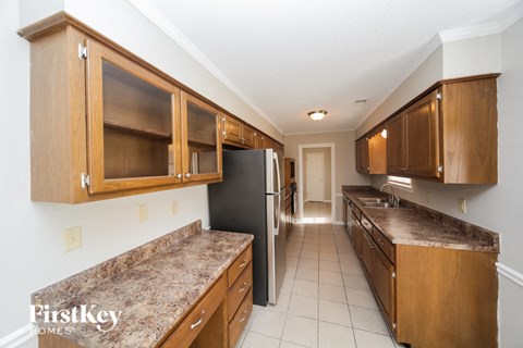 A kitchen with wooden cabinets and a granite countertop.