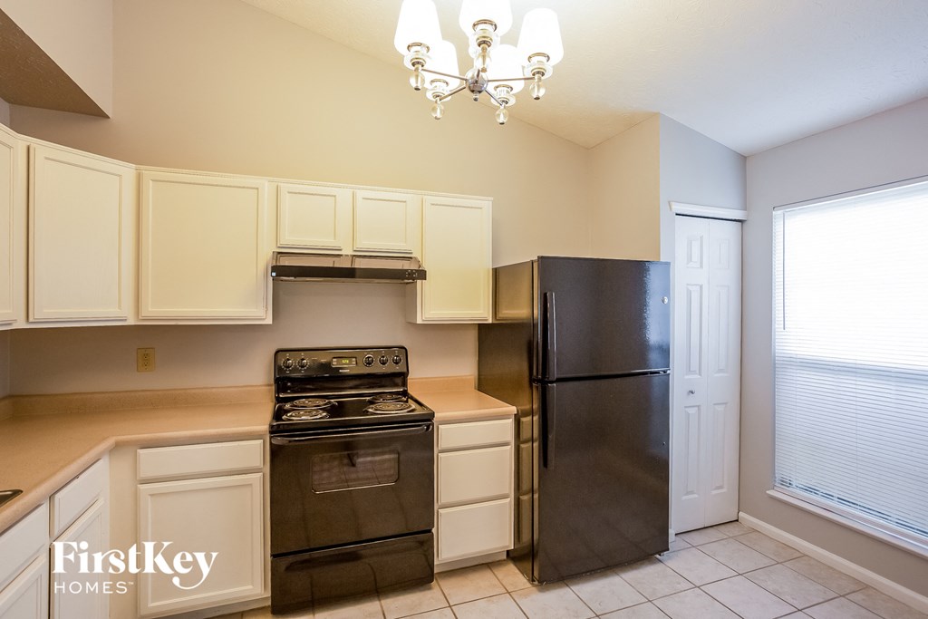 a kitchen with black appliances and white cabinets