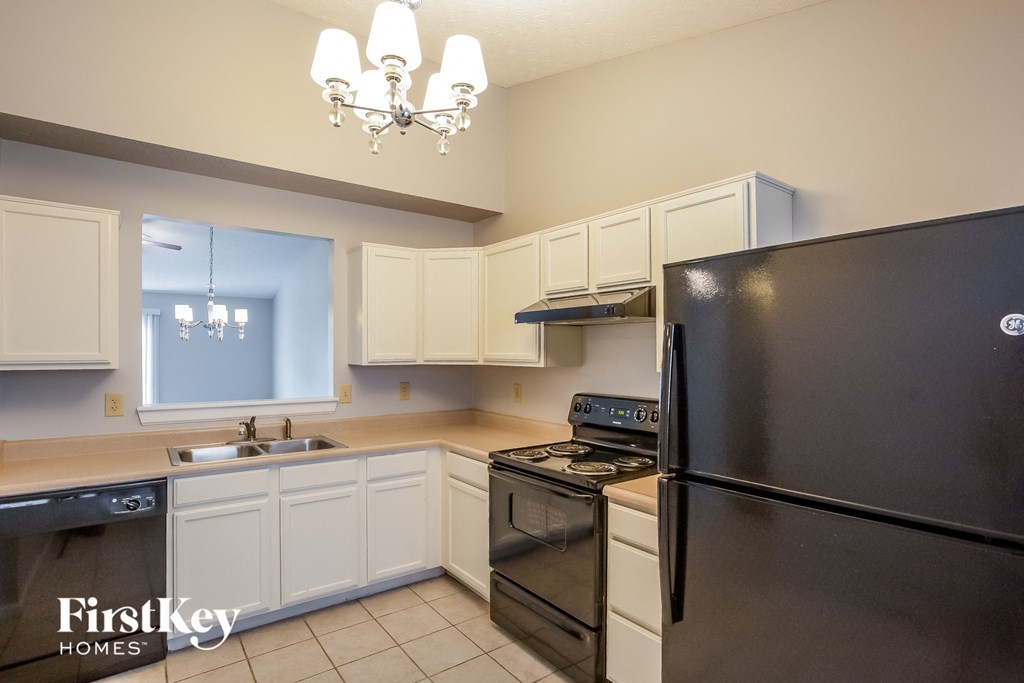 a kitchen with black appliances and white cabinets