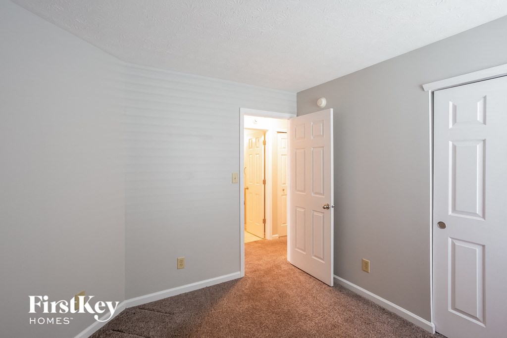 a bedroom with a closet and a door to a hallway
