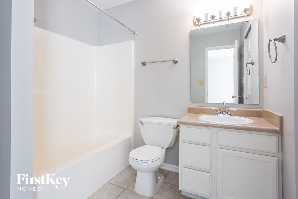 a white bathroom with a toilet and a sink