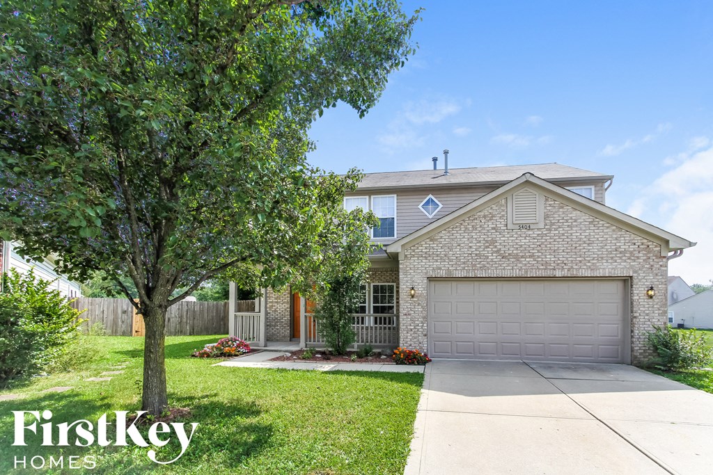a home with a garage door and a tree