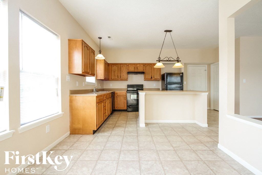 an empty kitchen with wooden cabinets and a white counter top