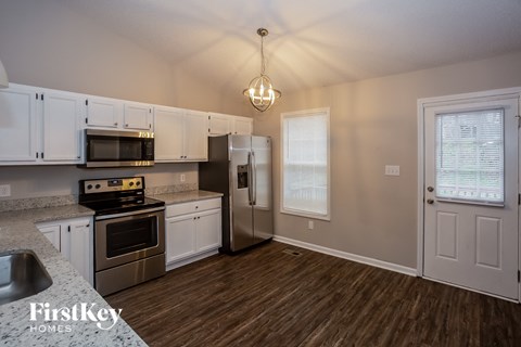 A kitchen with white cabinets and a stainless steel oven.